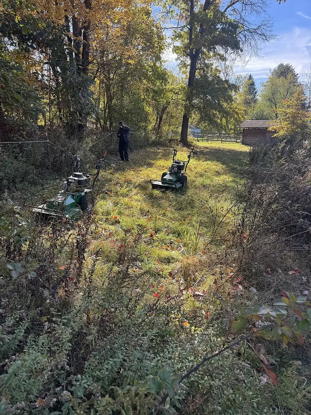 Cleared path with two brush mowers and a fence line