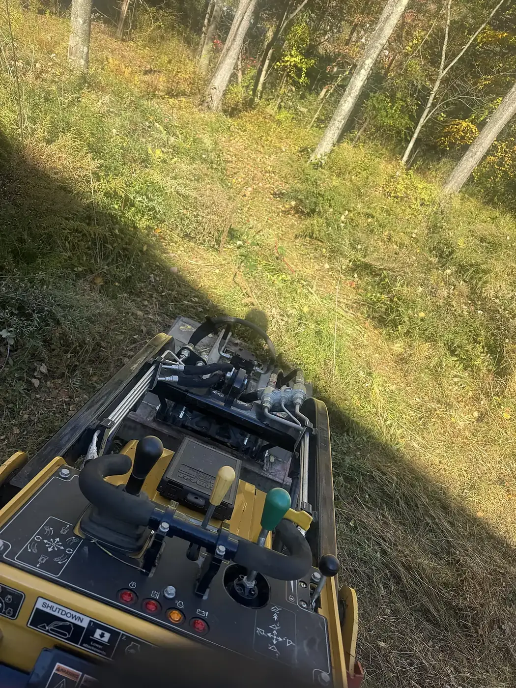 View from the controls of the tracked machine looking at a cleared hillside
